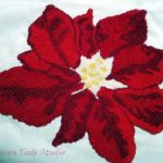 Poinsettia worked in French knots on linen; unfinished.