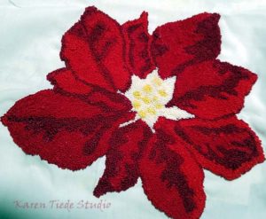 Poinsettia worked in French knots on linen; unfinished.