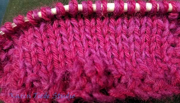 Swatch with two dark pink wool yarns.