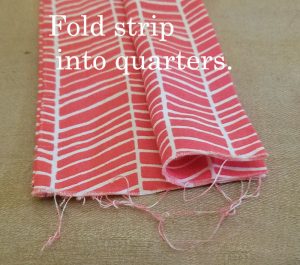 Fold the strip into quarters (like a W).