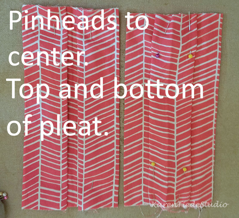 Pin center fold into a box pleat, pinheads toward center.