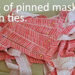 Stack of masks with ties pinned to each edge.